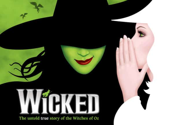 Wicked graphic shows a woman in white whispering to a woman in black witch's hat, green face and red lipstick, with flying creatures in a green background