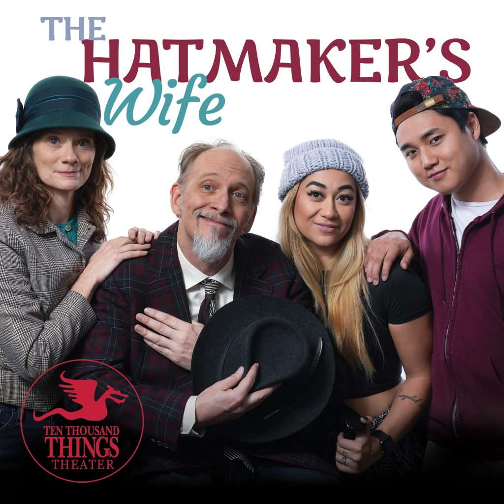 photo of four actors, two young woman and a young man around an older, balding, bearded man holding a black hat over his chest.